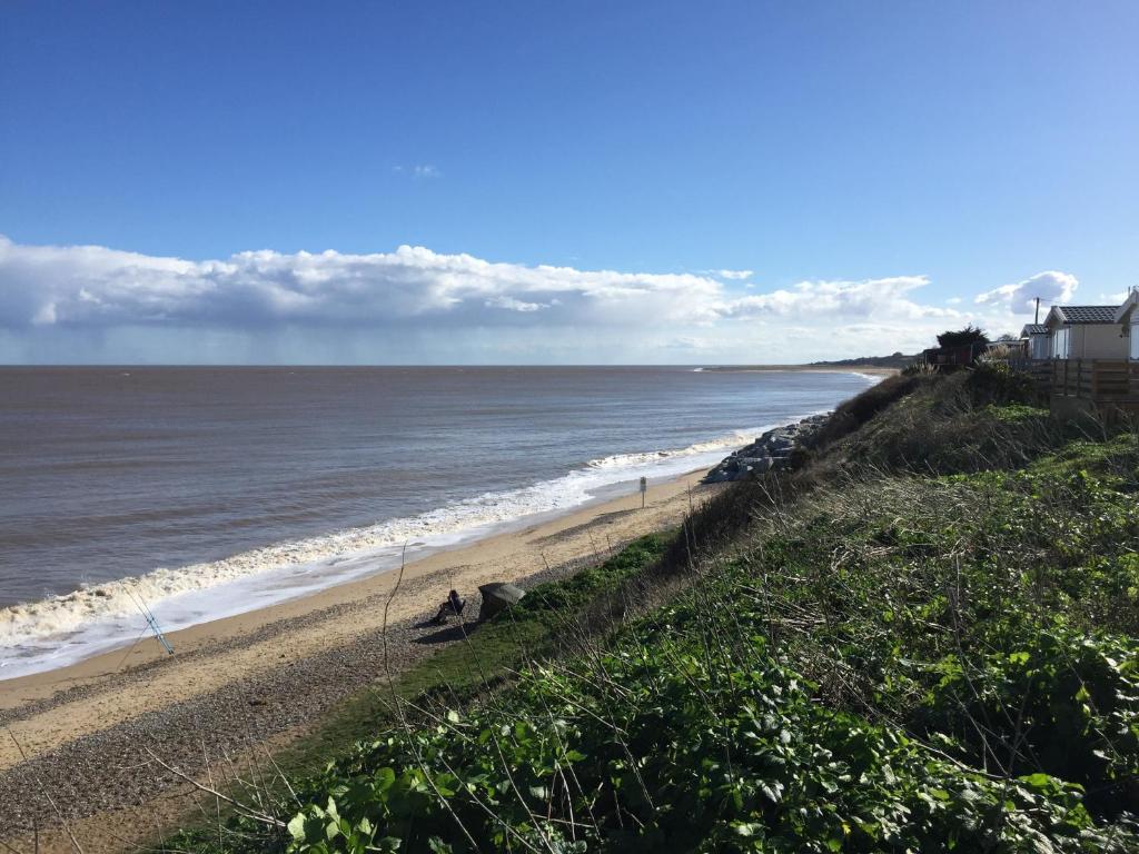 a beach with a house and the ocean at Beside the Seaside, Pakefield Holiday Park, Arbor Lane, Pakefield, Lowestoft NR33 7BE in Pakefield