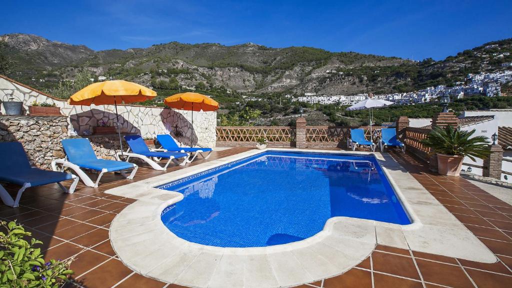- une piscine avec des chaises et des parasols sur une maison dans l'établissement Villa Francisco, à Frigiliana