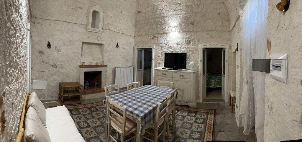 a room with a table and a tv in it at trulli Annina in Locorotondo