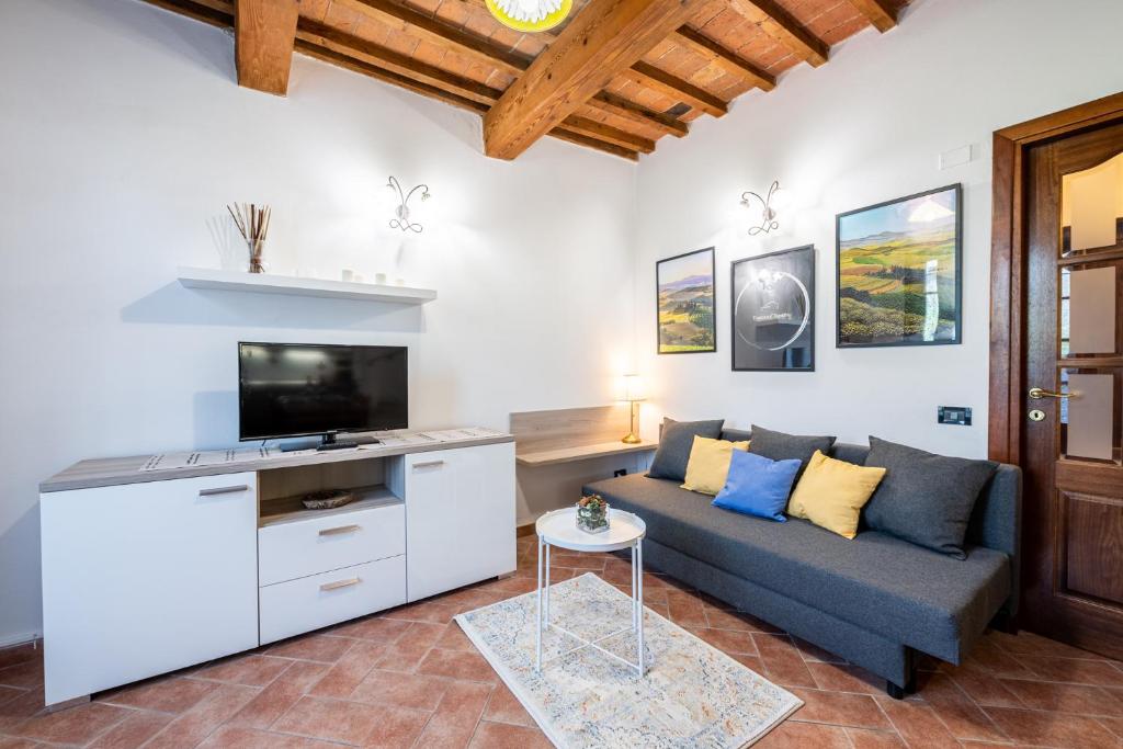 - un salon avec un canapé et une télévision dans l'établissement Homiday - Tuscany House - Parcheggio e Giardino Privato, à Pise