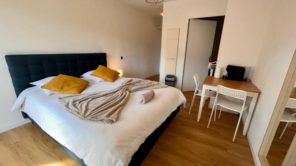 - une chambre avec un lit doté d'une tête de lit bleue et d'une table dans l'établissement Studio Grenoble Universités-Saint Martin D'hères, à Saint-Martin-dʼHères