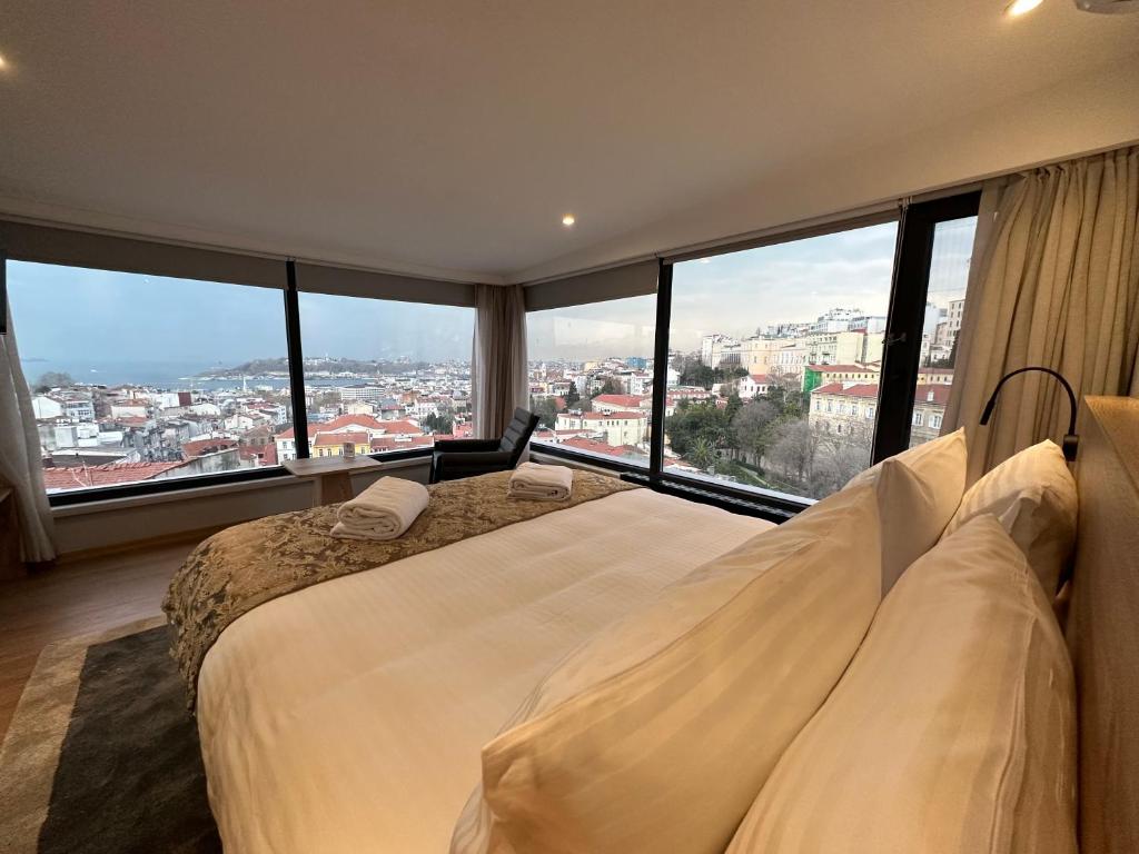 a bedroom with a large bed with large windows at Louis Rooms in Istanbul
