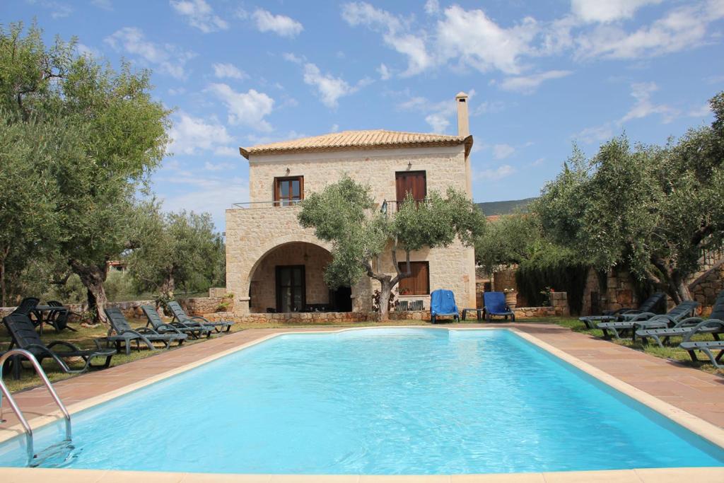 une piscine en face d'un bâtiment avec une maison dans l'établissement Maison Viros, à Kardamyli