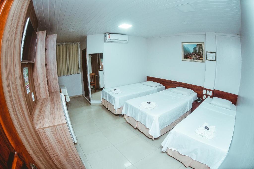 Habitación hospitalaria con 2 camas y espejo en Frota Palace Hotel, en Macapá