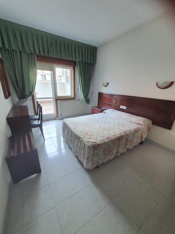 ein Schlafzimmer mit einem großen Bett und einem Fenster in der Unterkunft Flor de Loto in Ordes