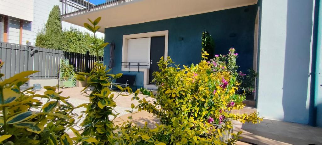 a blue house with flowers in front of it at Appartamenti Scilla e Lavinia in Riva del Garda