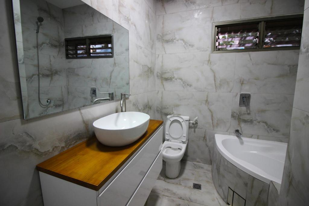 a white bathroom with a sink and a toilet at Sunset Inn in Eilat