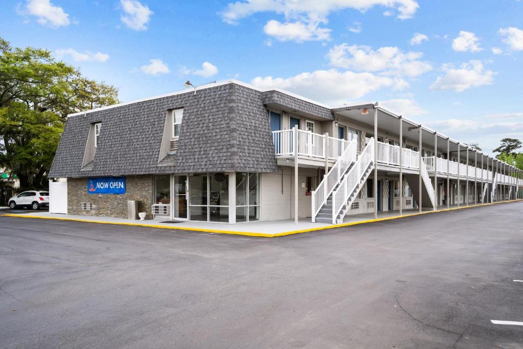 a large building with a parking lot in front of it at Studio 6 Wilmington, NC in Wilmington