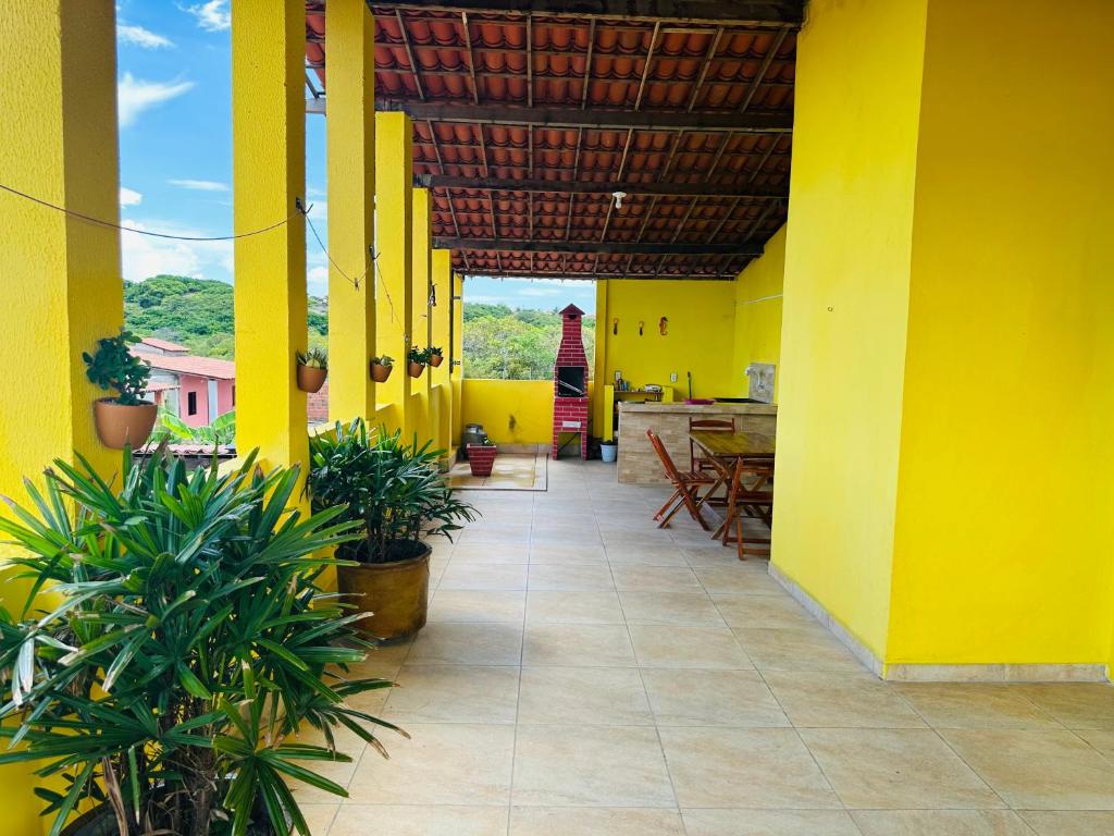 Zimmer mit gelben Wänden und einer Terrasse mit Pflanzen in der Unterkunft Vista Maravilhosa in Majorlândia