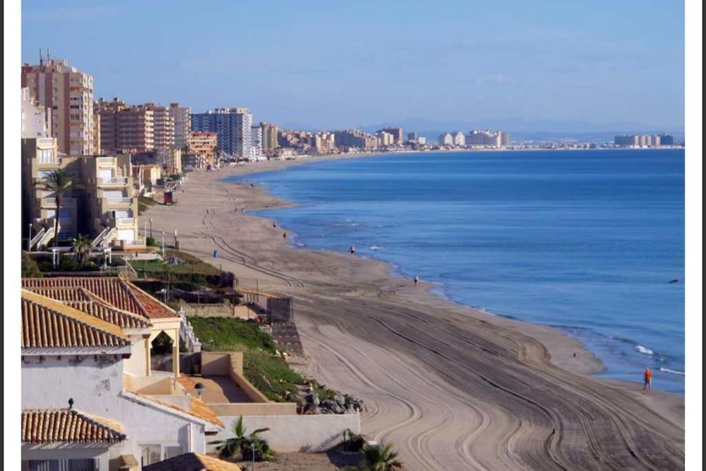 vistas a una playa con edificios y al océano en Apartamento en La Manga, en La Manga del Mar Menor