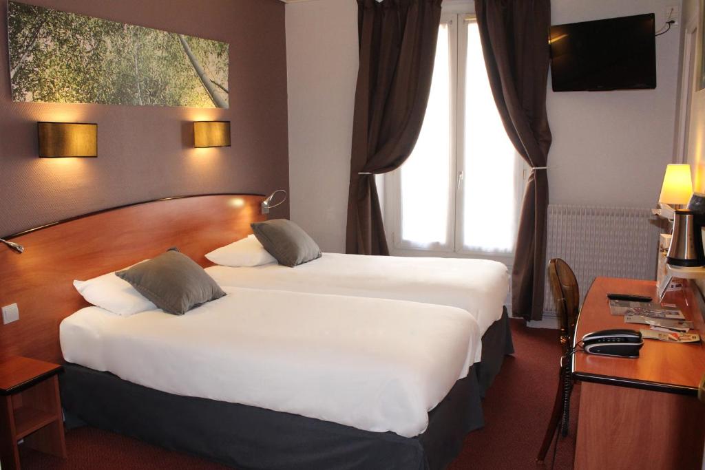 a hotel room with two beds and a desk at Kyriad Hotel XIII Italie Gobelins in Paris