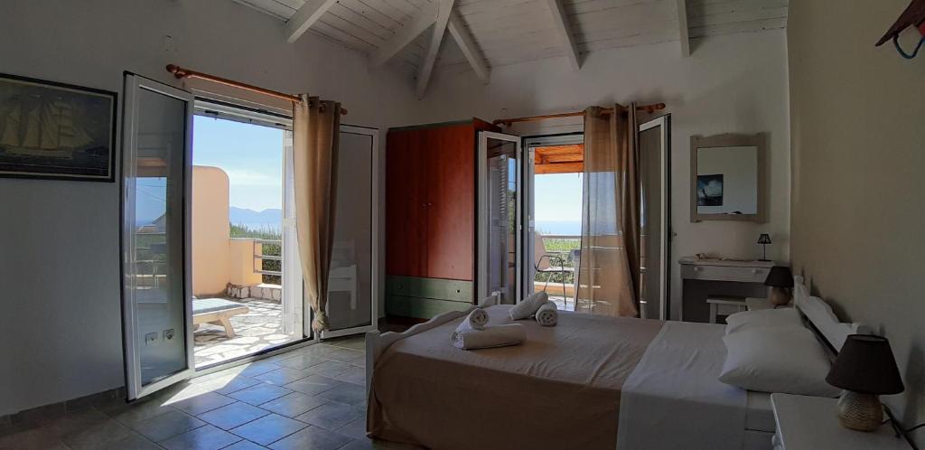 a bedroom with a large bed and a balcony at Il Veliero in Fiskardo