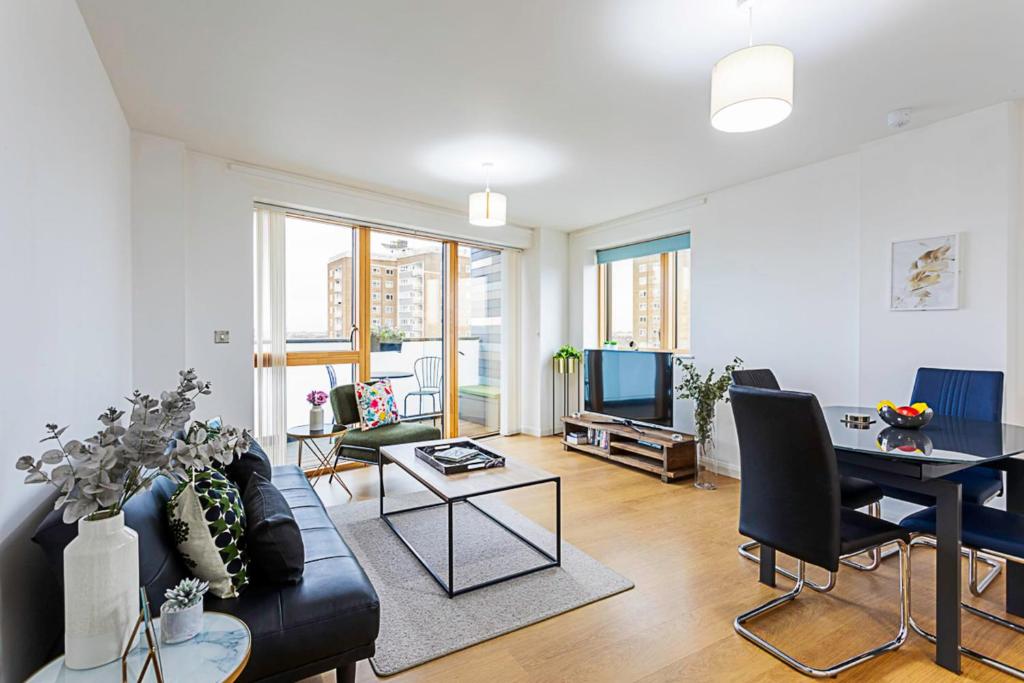 a living room with a couch and a table at Trendy Queen's Park Apartment with Views across London in London