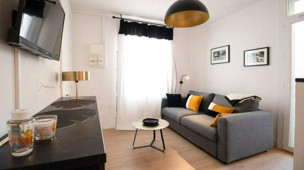 a living room with a couch and a table at Studio Casa Aelys - Quartier des Arènes - Béziers in Béziers