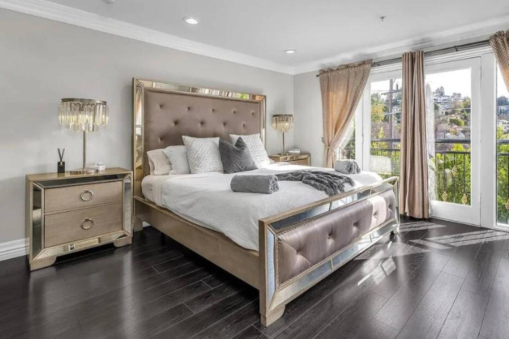 una camera da letto con un letto grande e una grande finestra di Barham Boutique Townhouse a Los Angeles
