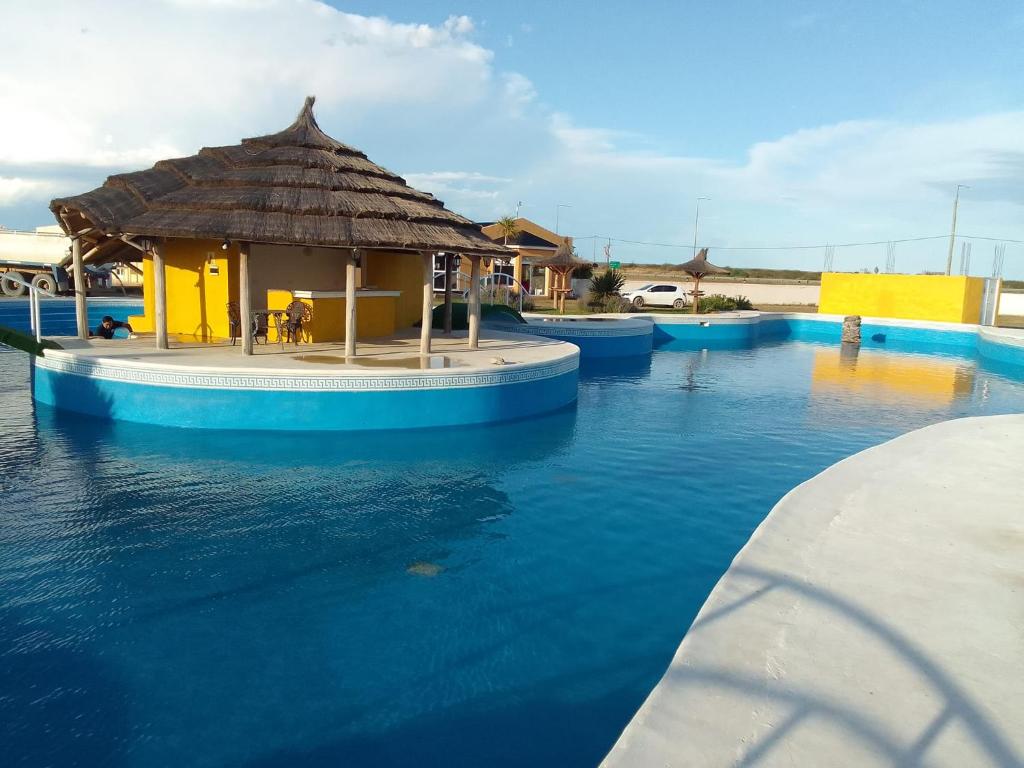 a swimming pool with a hut in the water at Hotel Copa Caribe in San Antonio Oeste
