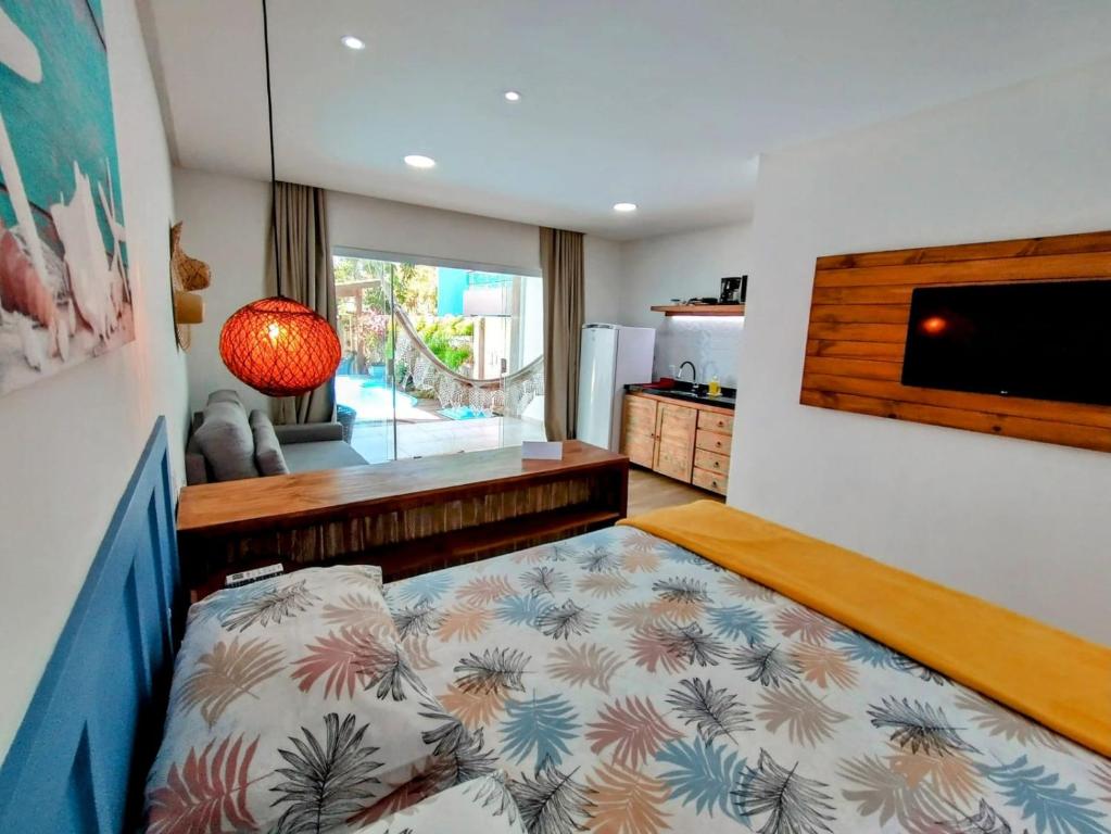 a bedroom with a bed and a tv in a room at Villa Bangalu in Porto De Galinhas