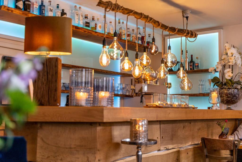 eine Bar mit Lichtern, die über einer Theke hängen in der Unterkunft Ferienwohnungen Blaue Maus Mirow in Mirow