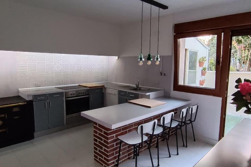 a kitchen with a counter and some chairs in it at Casa Vilas, Santiago de Compostela in Santiago de Compostela