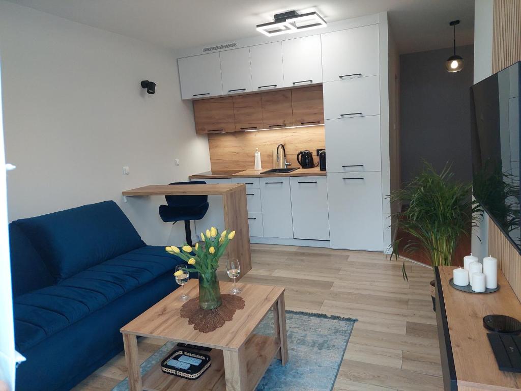 a living room with a blue couch and a table at Apartament Happy Stay in Rzeszów