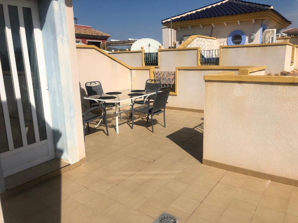 eine Terrasse mit einem Tisch und Stühlen auf dem Balkon in der Unterkunft Beautiful Villa in Murcia with pool just 10m away in Murcia