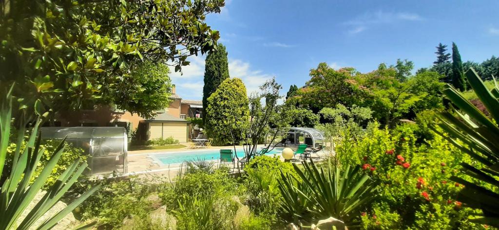a house with a swimming pool in a garden at Maison de 2 chambres avec piscine partagee jardin amenage et wifi a Le Thor in Le Thor
