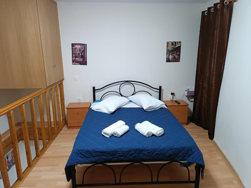 a bedroom with a blue bed with towels on it at Two-storey maisonette next to the port in Mantoúkion