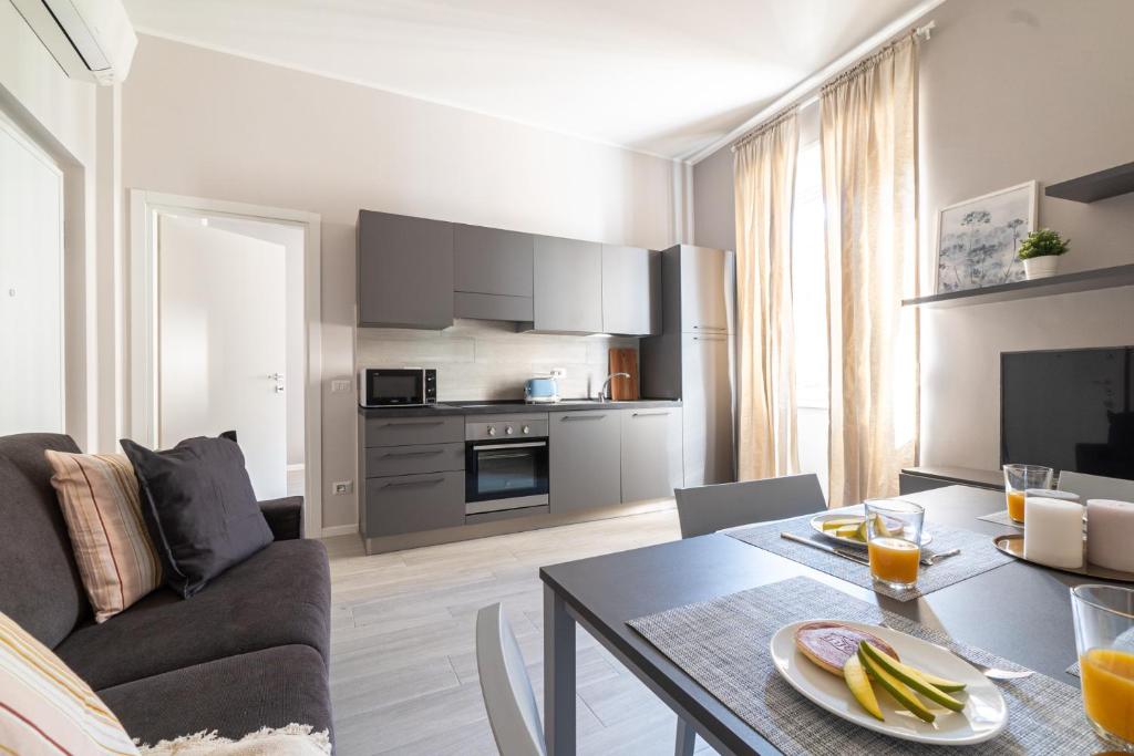 eine Küche und ein Wohnzimmer mit einem Tisch und einem Sofa in der Unterkunft Easylife - Accogliente residenza a due passi dal Duomo in Mailand