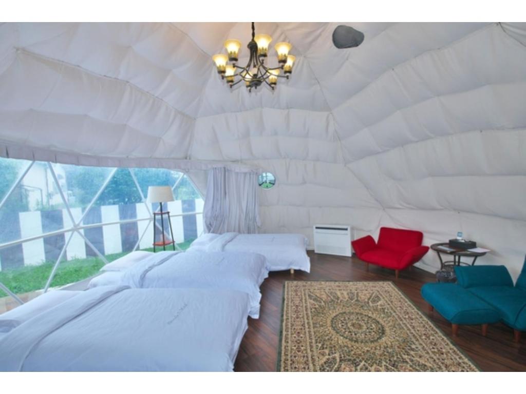 una camera con 2 letti e un lampadario a braccio in una tenda di Ducale Gran Resort 99 - Vacation STAY 00092v a Kujukuri