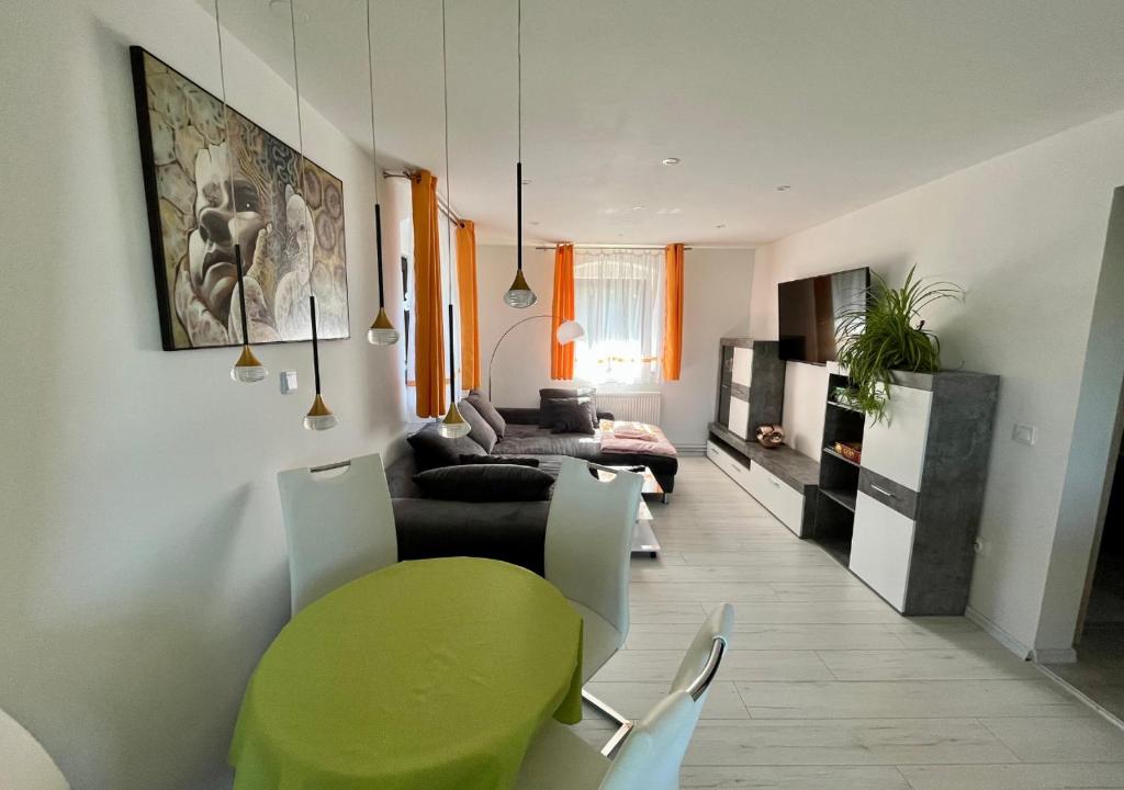 a living room with a green table and a couch at Ferien- und Businesswohnung Relax im ersten Stock in Sonnen