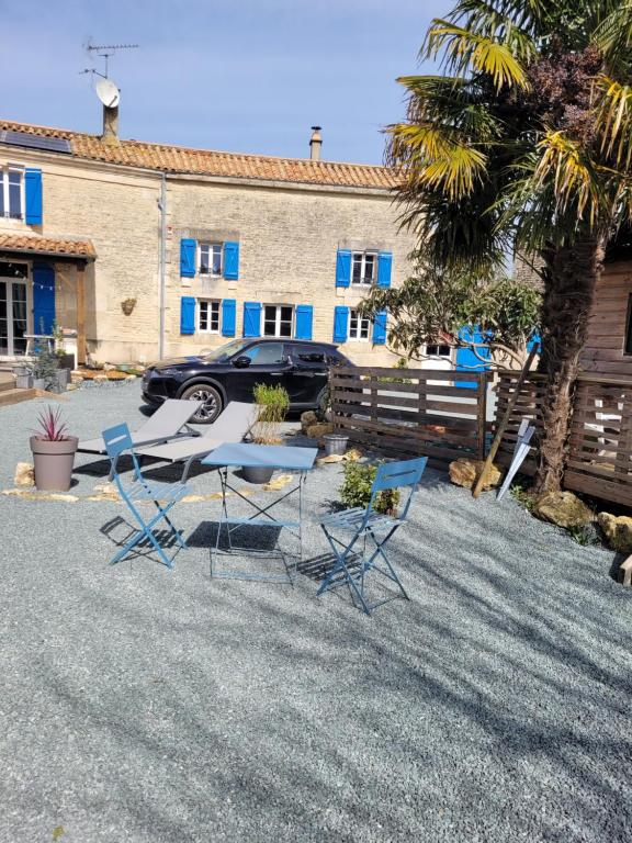 un groupe de chaises et une table devant un bâtiment dans l'établissement Gîte La Campeloise, à Villiers-en-Plaine