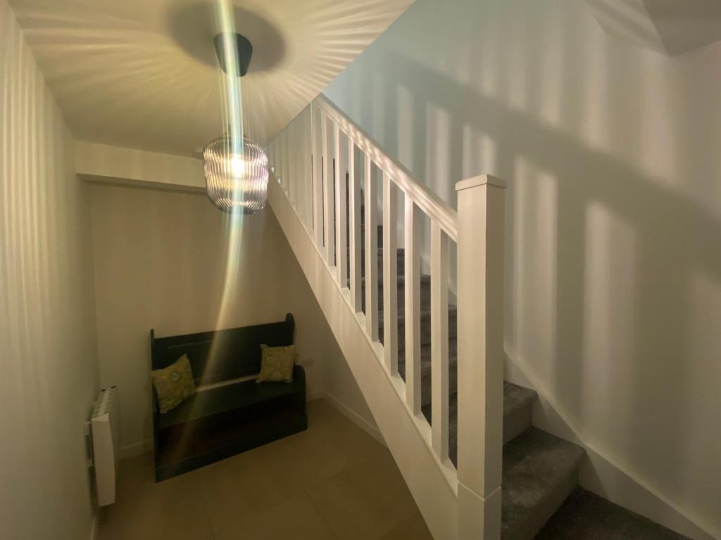 pasillo con escalera y lámpara de araña en Harry’s place, en Mullingar