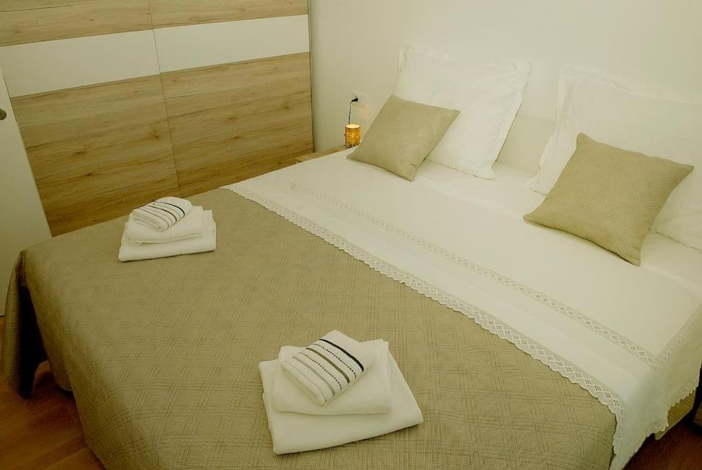 Una cama grande con dos toallas blancas. en Camino Split - apartment near Mall of Split, en Split