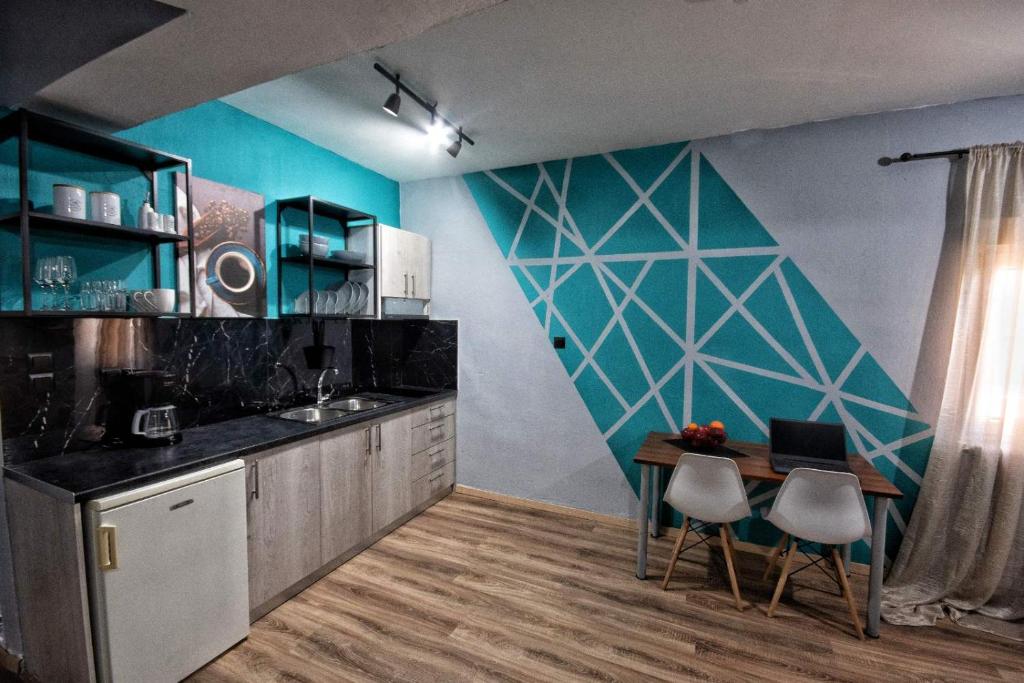 una cucina con pareti blu e tavolo e sedie di Urban Apartment Kastoria a Kastoria