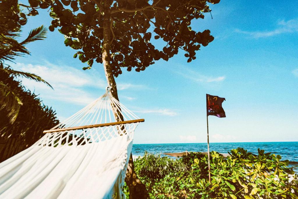 a hammock on the beach with a flag at Casa do Amor Caraíva in Caraíva