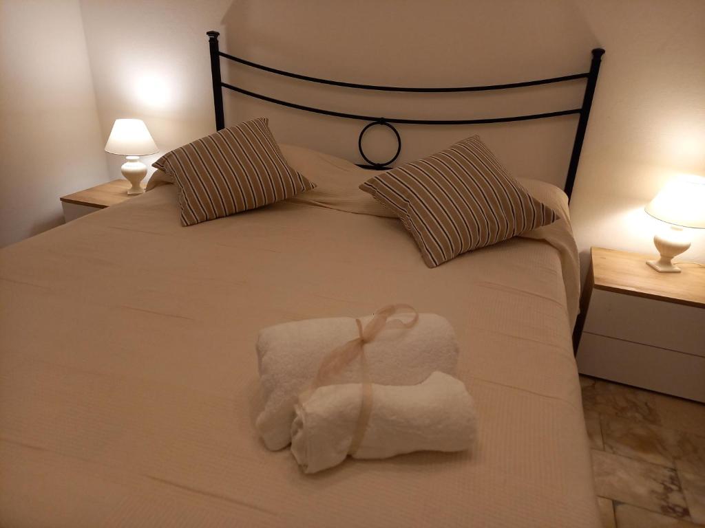 a bed with a white towel on it with two lamps at Bilocale con ingresso indipendente Katia in Massa