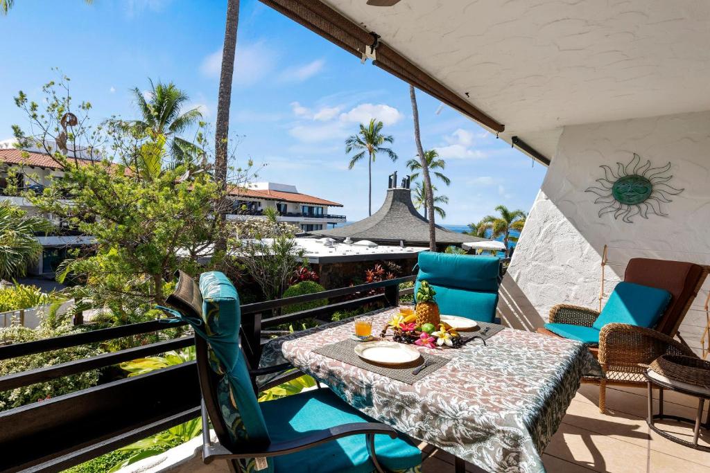 a patio with a table and chairs on a balcony at Casa De Emdeko 230 in Kailua-Kona