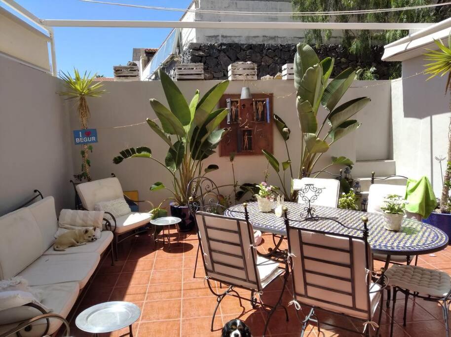 a patio with a table and chairs and plants at Maison en duplex & rooftop in Callao Salvaje