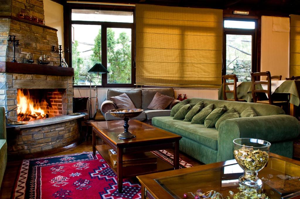 a living room with a couch and a fireplace at Alkistis Hotel in Portaria