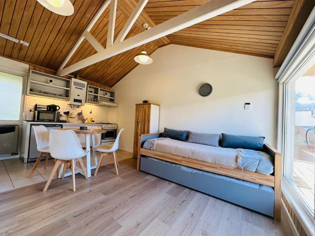 ein Schlafzimmer mit einem Bett und einem Tisch in einem Zimmer in der Unterkunft Gi´s House 4Pax in Ushuaia