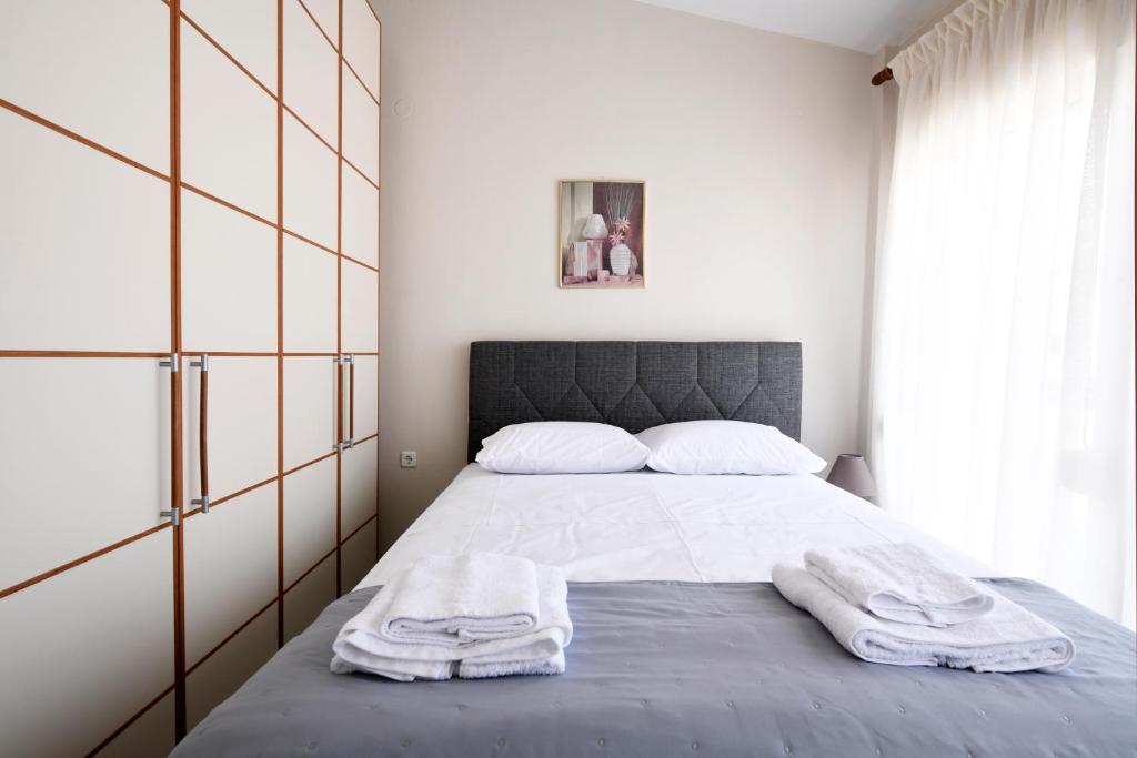 1 dormitorio con 1 cama con 2 toallas en Villa Bolero, en Nea Iraklitsa