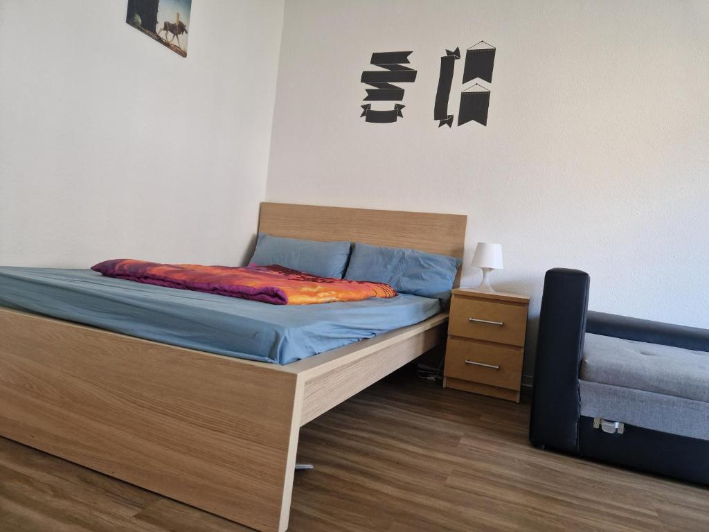 1 dormitorio con 1 cama con sábanas azules y mesita de noche en Abbey homestay en Frankfurt