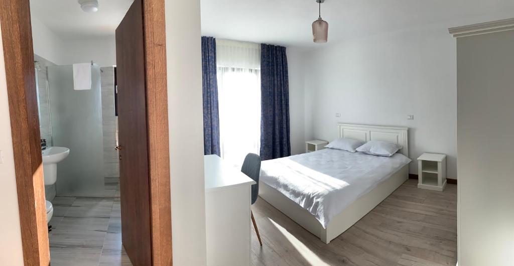 een slaapkamer met een bed en een badkamer bij Hotel Dia Lin in Borşa