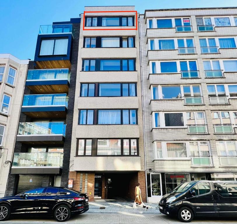 オーステンデにあるOstend Center Luxury Top Floor Apartment with Free Parkingの高層ビルの前に停車した車2台