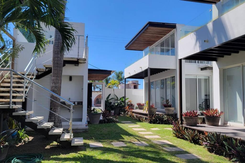 a row of white houses with stairs and plants at Luxurious Surf Resort in Pascuales Mexico Room 5 in Los Pascuales