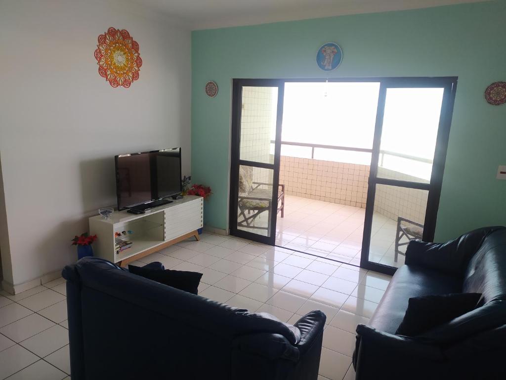 a living room with two couches and a television at Bela Vista Praia Grande in Solemar