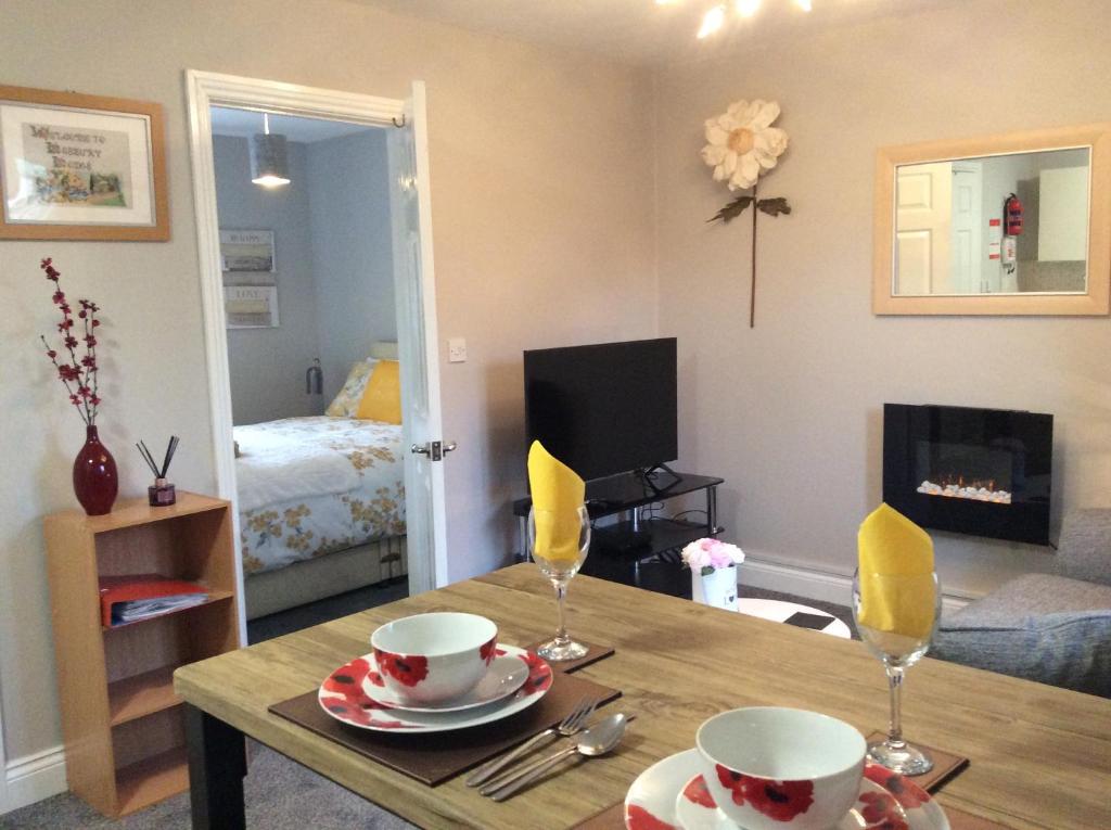 uma sala de estar com uma mesa e um quarto com uma cama em Lesbury Lodge - (a 'bijou residence') with hot tub em Alnwick