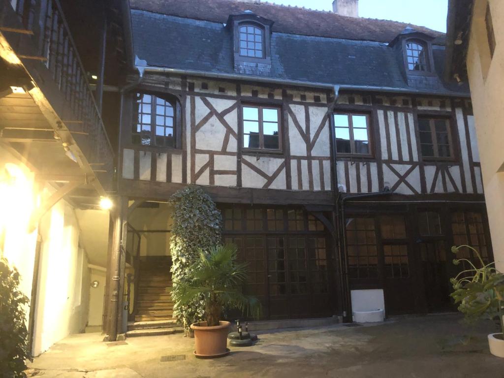 ein altes Gebäude mit einer Topfpflanze im Innenhof in der Unterkunft le vieux relais in Cosne-Cours-sur-Loire