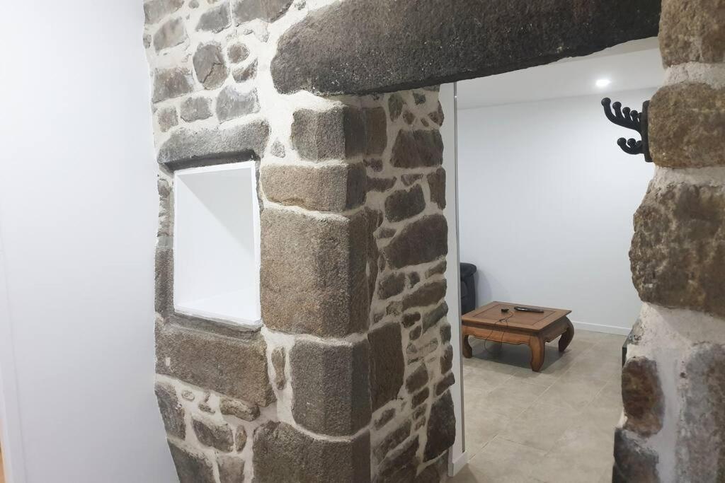 Habitación con chimenea de piedra y ventana en Appartement spacieux Saint-Malo, Dinard, Dinan et Dol, en Miniac-Morvan