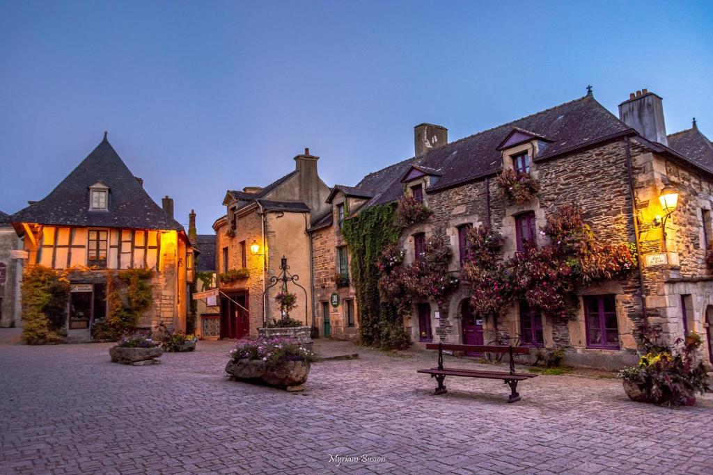 a large stone building with a bench in a courtyard at Chez Catherine in Rochefort-en-Terre
